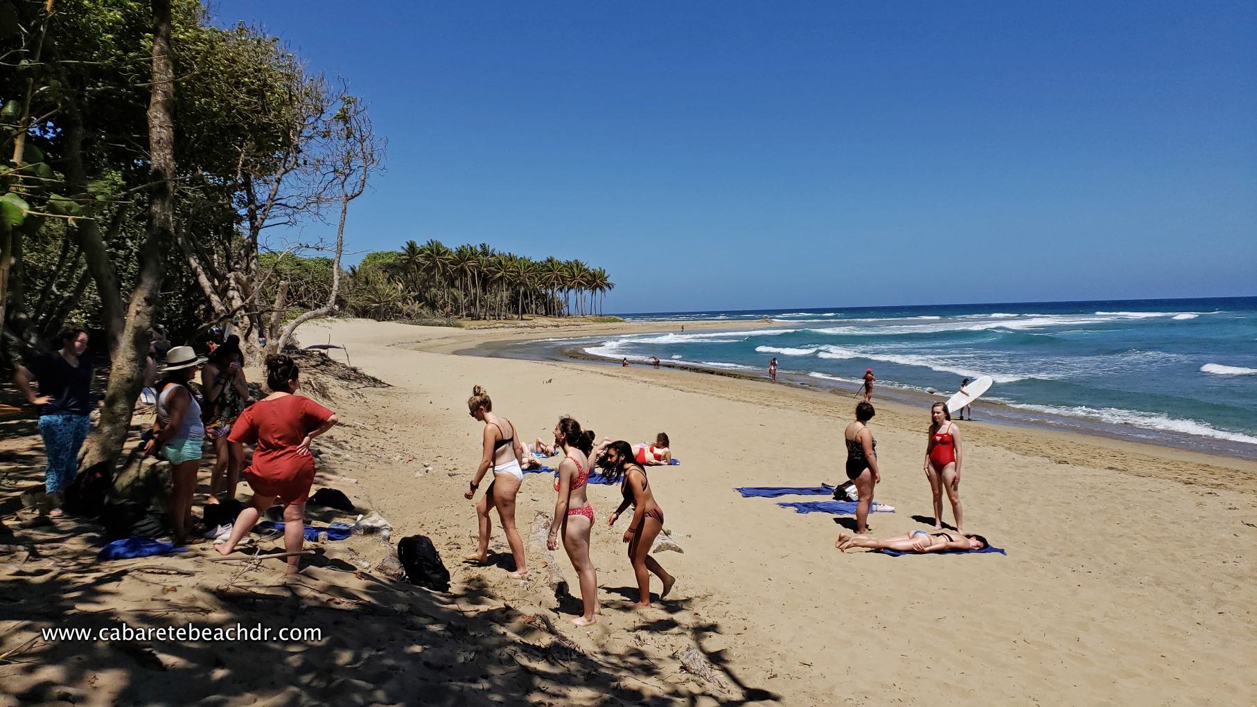 Tourists walk by the beach